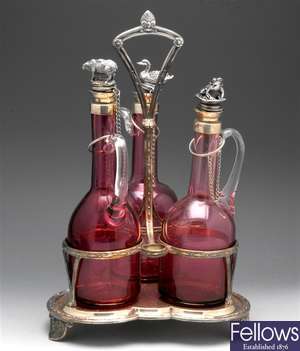 An Elkington & Co. silver plated cranberry glass 3 bottle decanter stand.