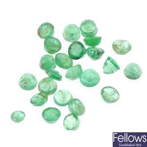 A quantity of loose circular-shape emeralds.