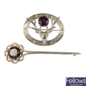 A selection of three silver Scottish brooches and an amber ring.