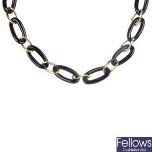 An onyx link necklace, a silver bangle and a charm bracelet.