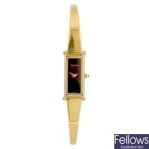 A gold plated lady's Gucci bangle watch.