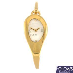 A gold plated quartz lady's Gucci 103 bangle watch.