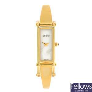 A gold plated quartz lady's Gucci 1500L bangle watch.