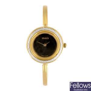 A gold plated quartz Gucci bracelet watch with a Bulova bracelet watch.