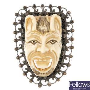 An early 20th century oriental silver ivory mask brooch.