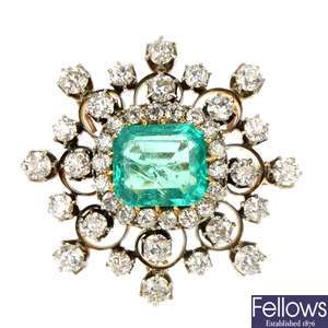 A late Victorian silver and gold emerald and diamond cluster brooch.