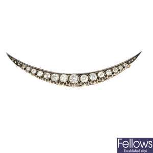 A late 19th century silver and gold diamond crescent brooch.