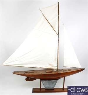 An early 20th century mahogany and stained wooden plank on frame model pond yacht