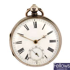 A silver key wind open face pocket watch with two other pocket watches.
