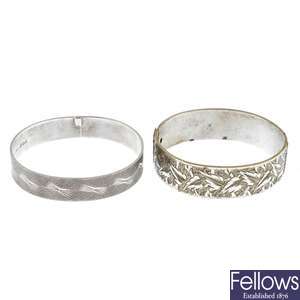 Two silver hinged bangles and a further silver plated bangle.