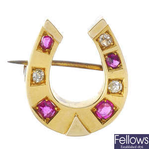 A late Victorian 15ct gold diamond and ruby horseshoe brooch, circa 1880.