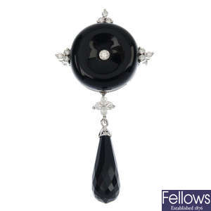 An 18ct gold onyx and diamond brooch.