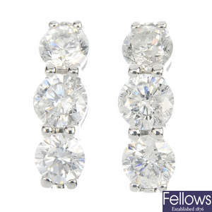 A pair of 9ct gold diamond three-stone ear studs. 
