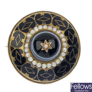 A late Victorian gold onyx, split pearl and enamel mourning brooch.