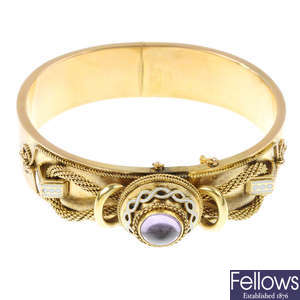 A late 19th century 15ct gold amethyst and enamel hinged bangle.