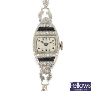 A lady's early 20th century platinum diamond and onyx cocktail watch.