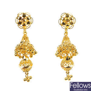 A pair of diamond ear studs with a pair of ear pendants.