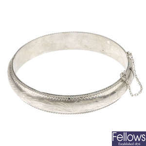 A selection of sixteen silver and white metal bangles.