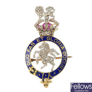An early 20th century 15ct gold and platinum gem-set and enamel Regimental brooch.