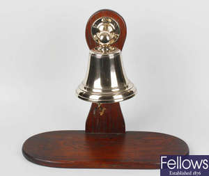 An early 20th century alloy bell on oak stand
