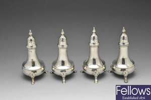A set of four George III silver pepper casters.