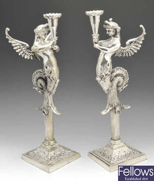 A pair of plated ornamental candlesticks.