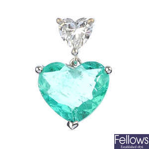 An emerald and diamond double heart pendant.