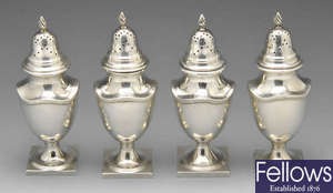 A set of four Edwardian silver casters.