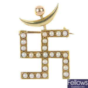 An early 20th century 15ct gold seed pearl Swastika and crescent moon brooch.