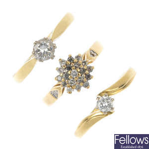 A selection of three 18ct gold diamond rings and a 9ct gold garnet ring.