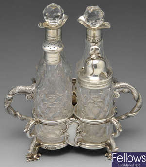 A William IV silver cruet stand with serpent handles.