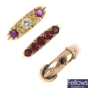A selection of three garnet and diamond rings.