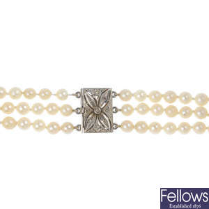 A cultured pearl three-row necklace with diamond-set clasp.