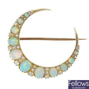 An early 20th century 12ct gold opal and diamond crescent brooch.