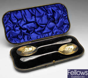 An Edwardian cased pair of silver serving spoons & preserve spoons.
