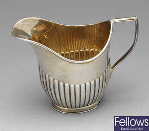 A small Edwardian cream jug, Victorian pierced dish, silver tea strainer etc.