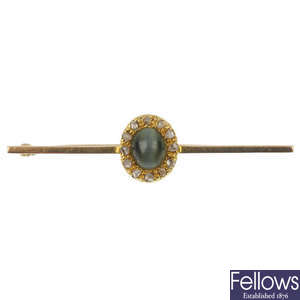 An early 20th century gold cat's-eye and diamond bar brooch.