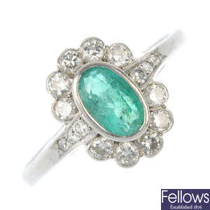 A platinum emerald and diamond cluster ring.