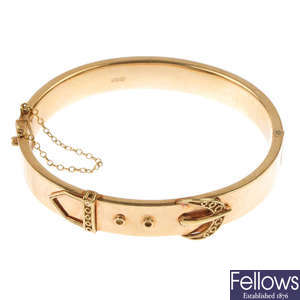 A 9ct gold stylised buckle hinged bangle.