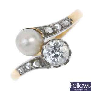 An early 20th century silver and 18ct gold diamond and cultured pearl two-stone crossover ring.