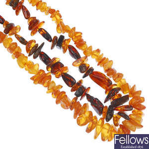 Six modified amber bead necklaces and two red plastic bead necklaces.