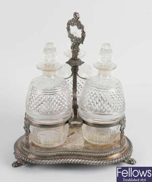 A silver plated stand holding three glass decanters, etc.