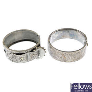 Two silver bangles and a further bangle of buckle design.