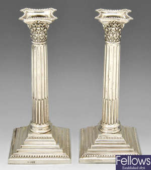 A pair of late Victorian filled silver candlesticks.