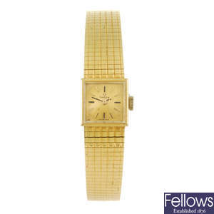 OMEGA - a lady's yellow metal bracelet watch.