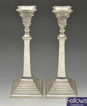 A pair of modern silver candlesticks with Corinthian capitals.