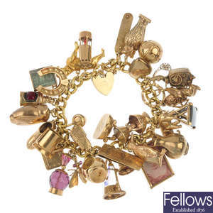 A 9ct gold charm bracelet with thirty-one charms.