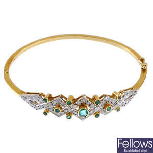An 18ct gold emerald and diamond hinged bangle.