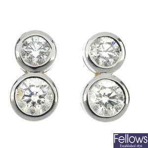 A pair of 18ct gold diamond two-stone ear-studs.