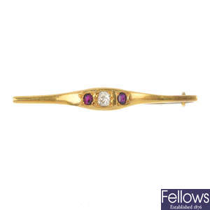An early 20th century gold diamond and ruby three-stone bar brooch.